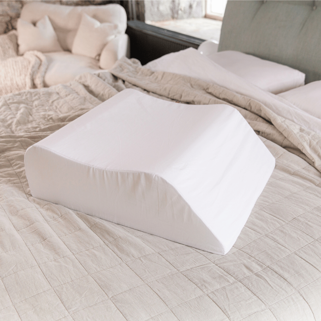 Putnams contoured leg rest pillow on a bed (image 6)